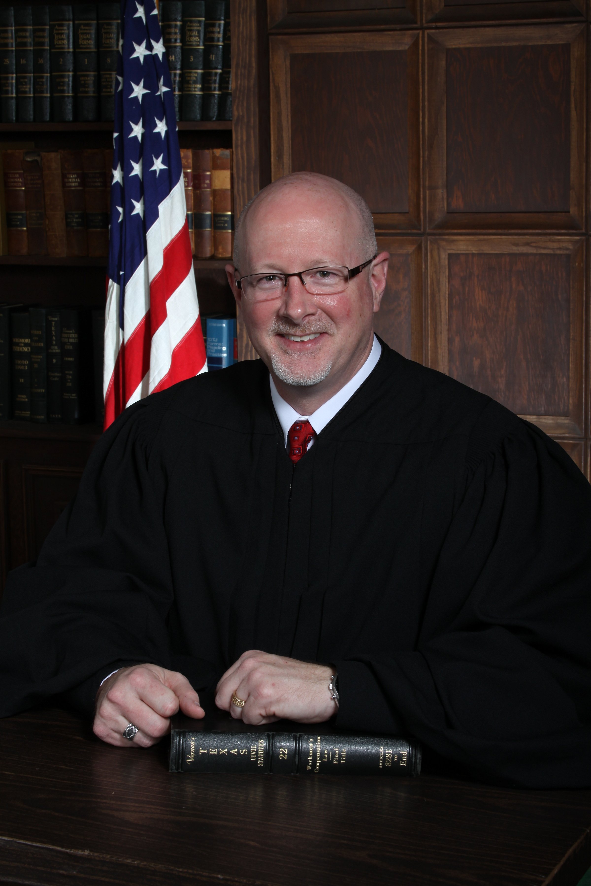 Hon. K. Randall Hufstetler in judicial robe with American Flag behind him
